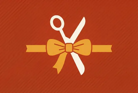 scissors cutting a ribbon bow on a red-orange card