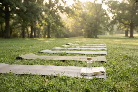 yoga mats rolled out on the grass of a park